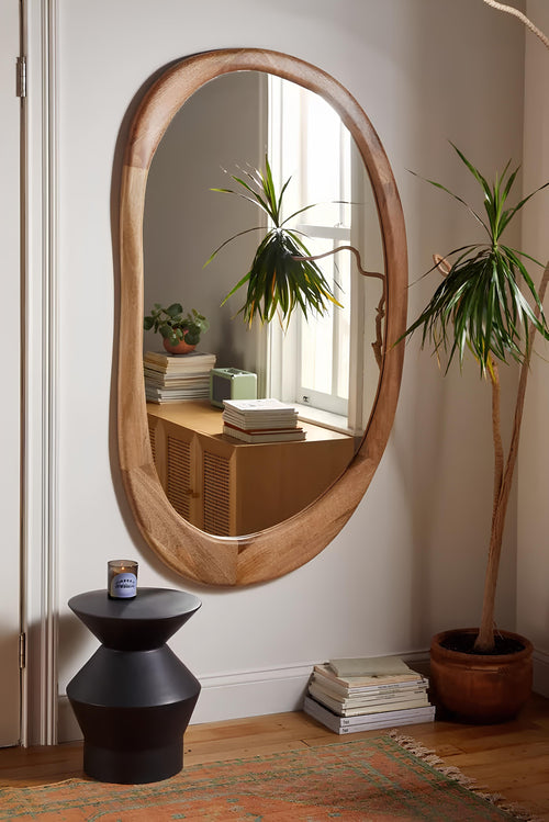 Large rattan wall mirror as a statement piece in an Indian living room - Akway